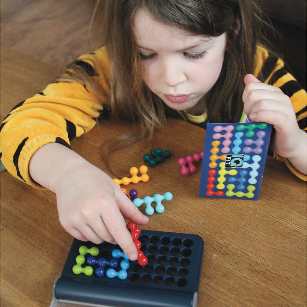 Child playing Smart Games IQ Fit logic puzzle game